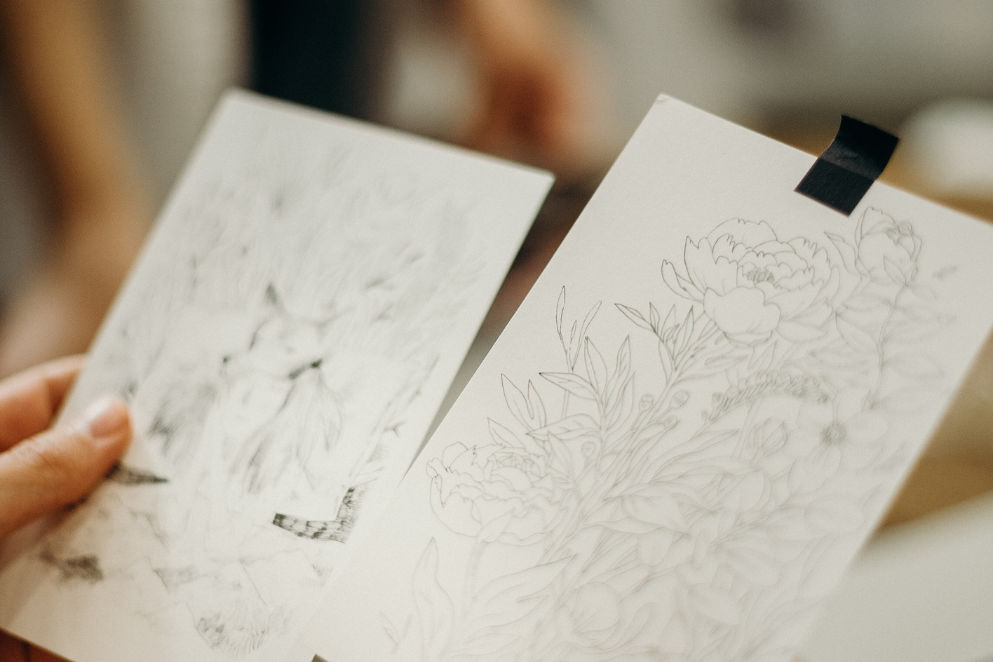 Dwa szkice trzymane przez mężczyznę