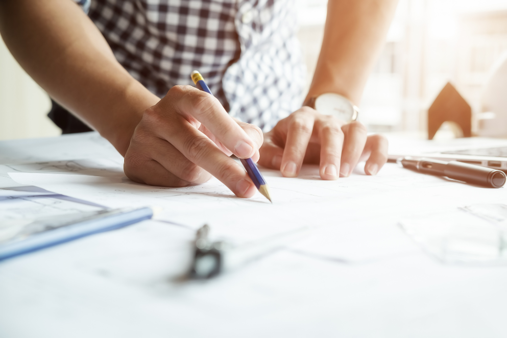 Mężczyzna z zegarkiem i ołówkiem w dłoni zajmujący się szkicowaniem