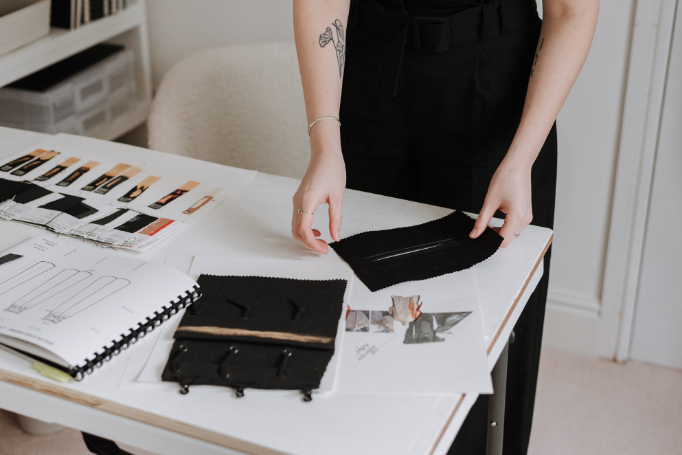 Szkicownik leżący na biurku w otoczeniu próbek materiału